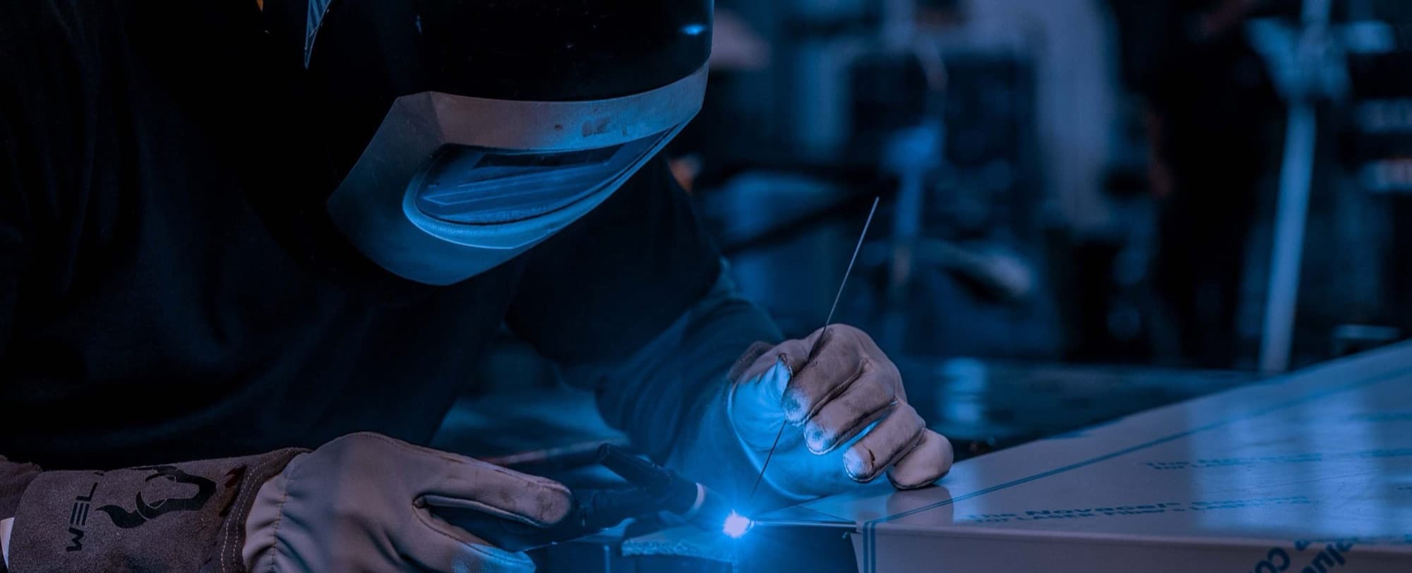 Operatore che salda un pannello in acciaio inox